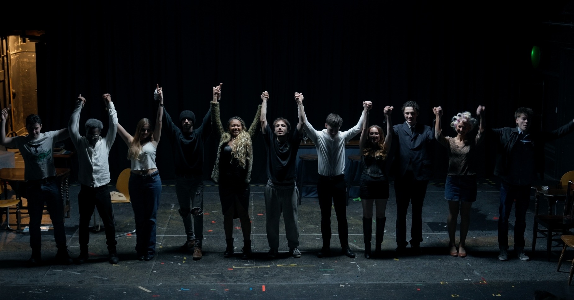 Group of actors holding their hands up